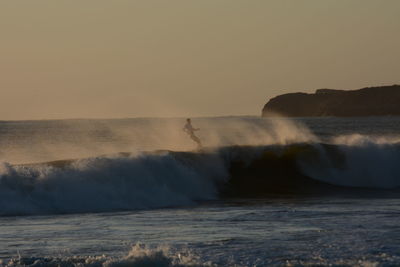 Water splashing in sea against clear sky