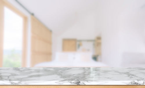 Close-up of white curtain on table by wall at home