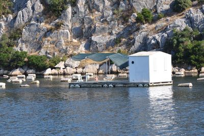 Buildings by sea against rock formation