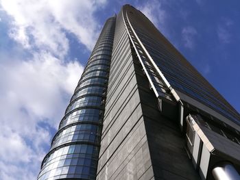 Low angle view of modern building against cloudy sky