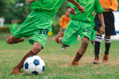 Low section of man playing soccer on field