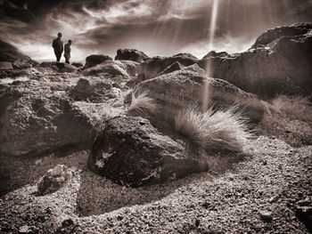 Man standing on rock against sky