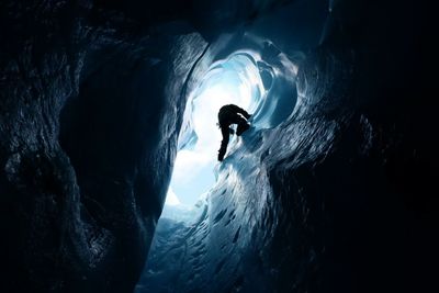 Silhouette person on ice in cave