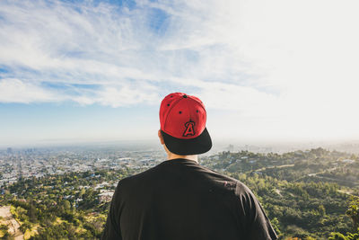 Rear view of man standing on landscape against sky