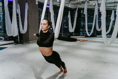Full length of ballet dancer practicing dance at gym