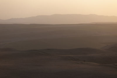 Scenic view of desert against sky during sunset