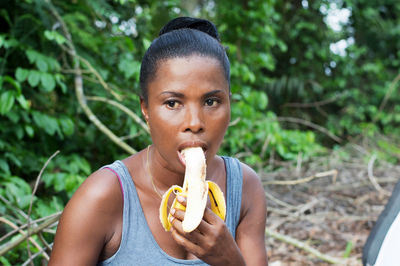 Picnics, this young woman eats ripe banana.