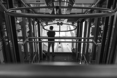 Rear view of a man standing in lift