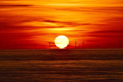 Scenic view of landscape against orange sky