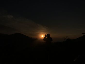 Silhouette person against sky during sunset