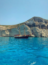 Sailboat in sea against clear blue sky