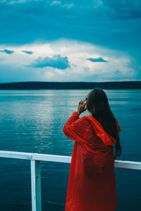 Rear view of woman looking at sea against sky