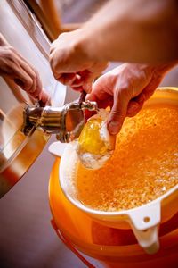 Close-up of man pouring drink in glass