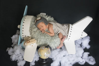 High angle view of woman lying down against black background