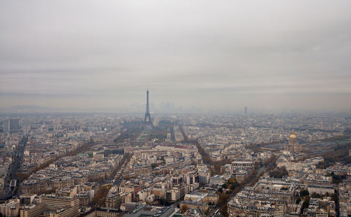 High angle view of city buildings against cloudy sky