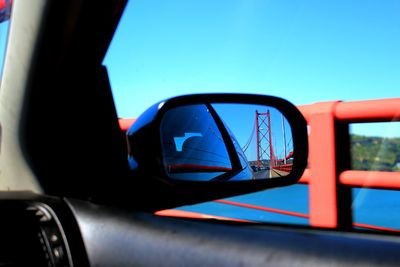 Reflection of bridge in side view mirror of car