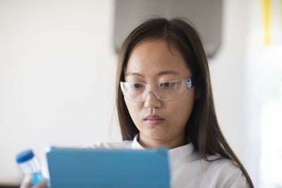 Scientist female with sample and tablet in a lab