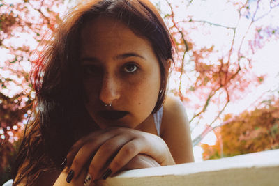 Thoughtful young woman sitting on bench in park