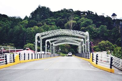 Road by bridge against sky