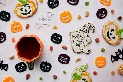 Homemade pumpkin, ghost cookies, halloween  decorations, nuts and candied fruits.  pumpkin tea cup