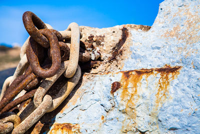 Close-up of rusty metal chain on rock