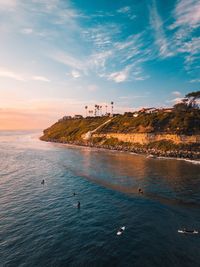 Scenic view of surfers off the coast from above