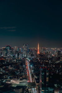 Illuminated cityscape against sky at night