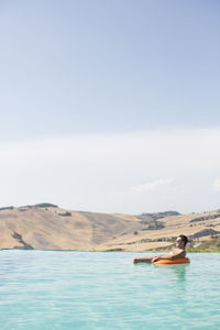 Mid adult man relaxing in swimming pool