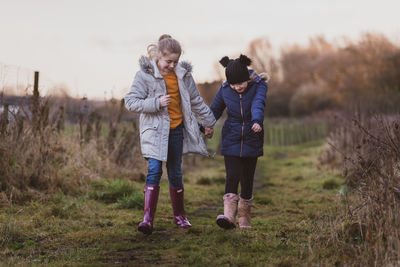 Front view of friends walking on field