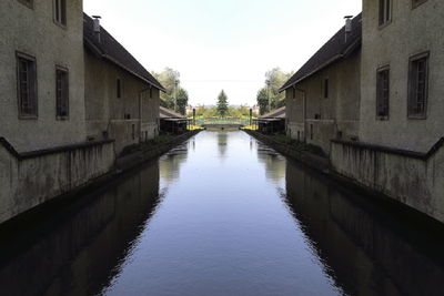 Canal amidst buildings against sky