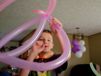 Boy holding balloons at home