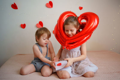 Valentine's day, boy and girl, children open an envelope with a valentine