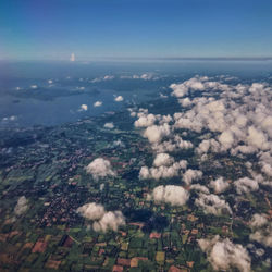 High angle view of airplane flying over landscape against sky