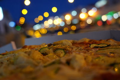 Close-up of pizza in city at night