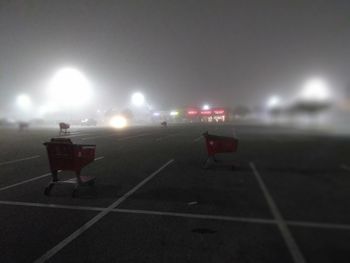 Illuminated lights on soccer field against sky at night