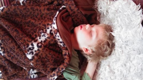Close-up of cute baby lying on sofa at home