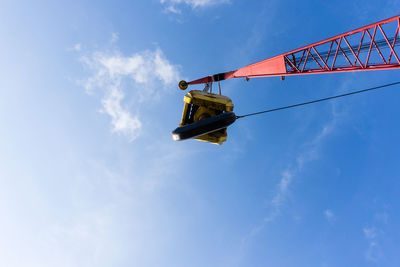 Low angle view of crane against sky