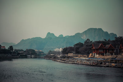 Houses by bay against clear sky