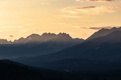 Scenic view of silhouette mountains against sky during sunset