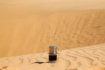 Drip black coffee in vietnamese style with condensed milk on a red method of making in a desert.