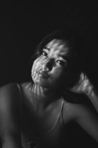 Portrait of woman against black background