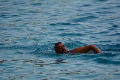 Portrait of shirtless man lying in swimming pool