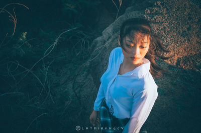 Young woman looking away while standing on land