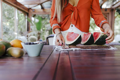 Midsection of woman standing on table