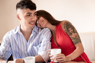 Young couple drinking coffee on table outdoors