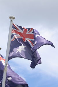 Low angle view of flag flags against sky