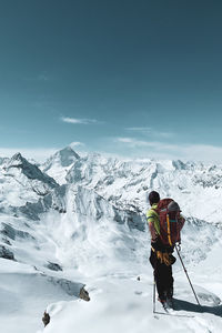 People on snowcapped mountain against sky