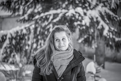 Portrait of smiling young woman standing outdoors during winter