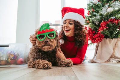 Portrait of smiling young woman with dog sitting at home