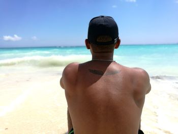 Rear view of shirtless man on beach